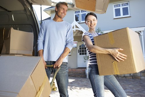Professional movers packing and protecting furniture for transport